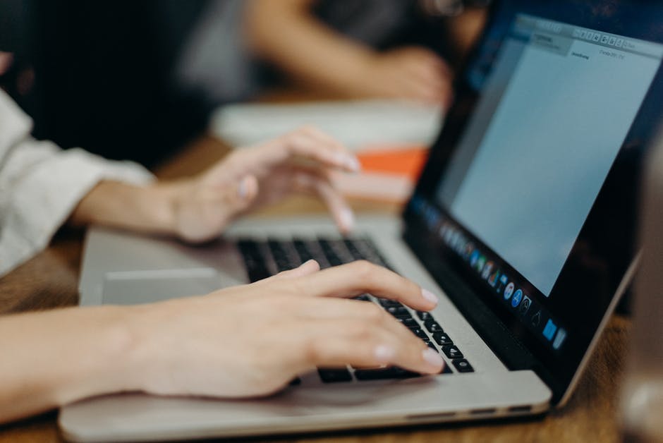 person writing on laptop